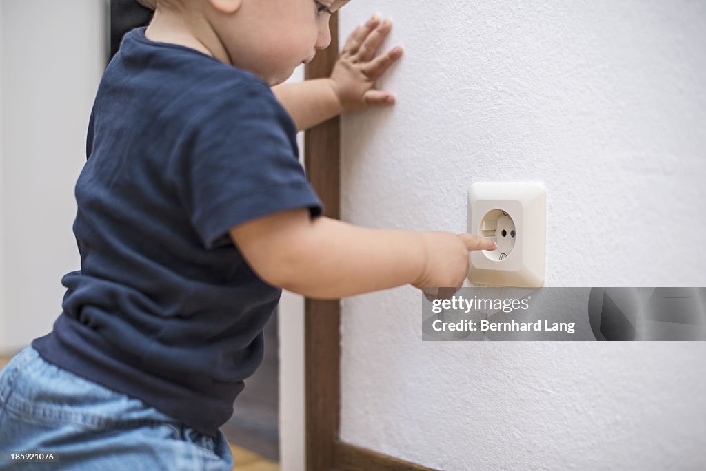 Little boy (1 y) wants to touch plug socket