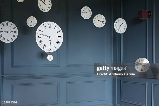 hanging clocks in sitting room - tageszeit stock-fotos und bilder