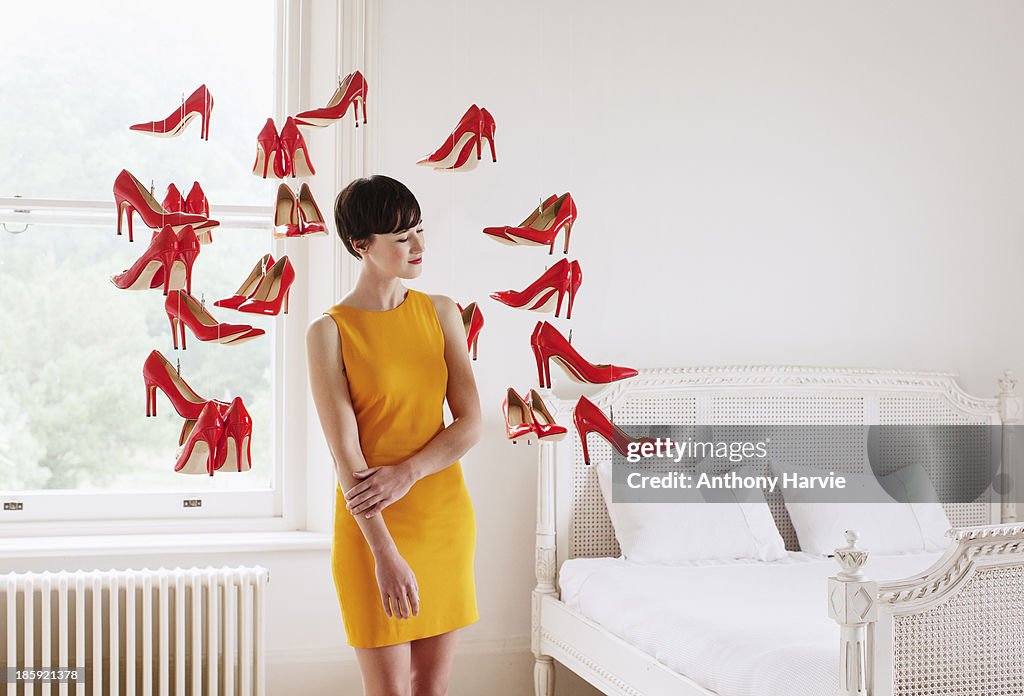 Woman in bedroom with hanging red shoes