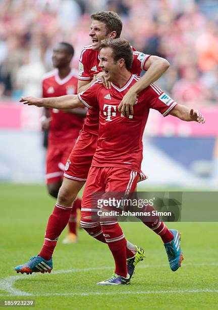 Mario Goetze of Muenchen celebrates with team mate Thomas Mueller after scoring his team's 3rd goal during the Bundesliga match between FC Bayern...