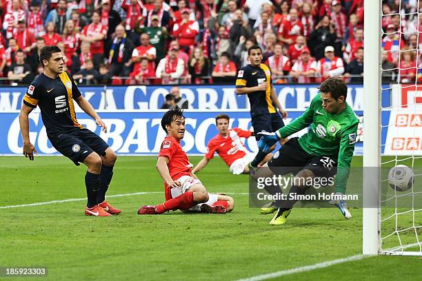 Shinji Okazaki of Mainz scores his team's second goal against goalkeeper Faniel Davari of Braunschweig during the Bundesliga match between 1. FSV...