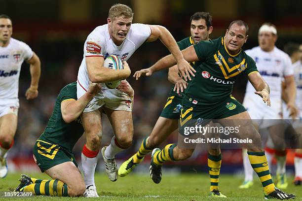 Tom Burgess of England cuts between Luke Lewis and Matthew Scott of Australia during the Rugby League World Cup Group A match between Australia and...