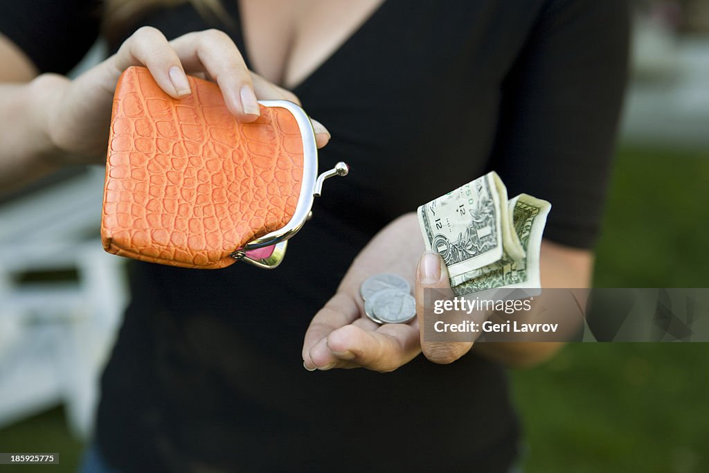 Woman holding a change purse and US currency