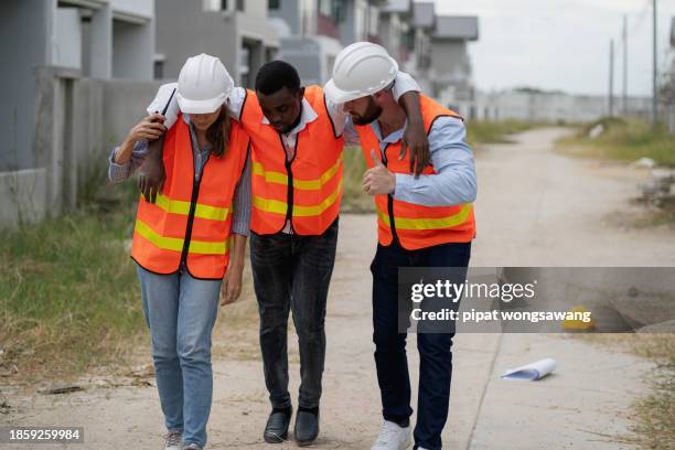 workers on a construction site suffer from heatstroke due to the extremely hot weather. - hyperthermia stock pictures, royalty-free photos & images
