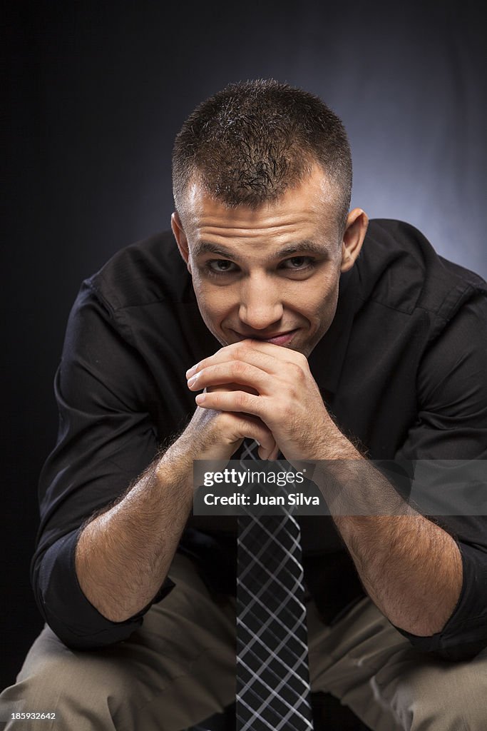 Young businessman sitting down smiling