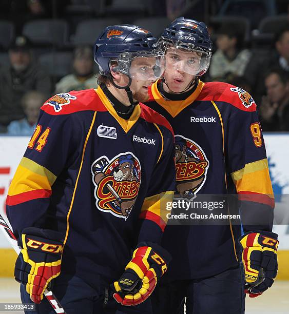 Connor McDavid chats with teammate Dane Fox of the Erie Otters during a play stoppage against the London Knights during an OHL game at the Budweiser...