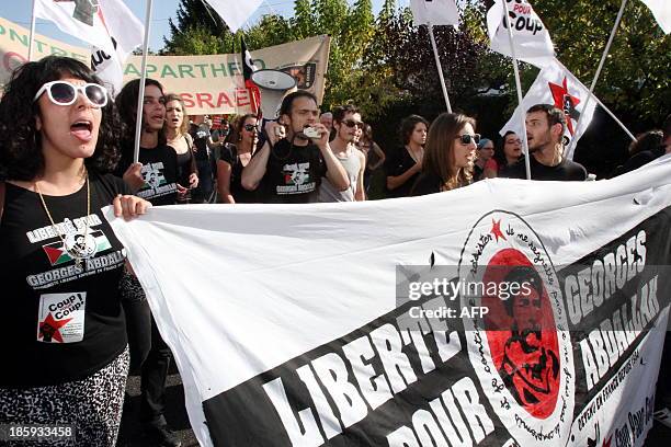 People hold a banner and shout slogans as they take part in a protest calling for the liberation of Lebanese activist Georges Ibrahim Abdallah, in...