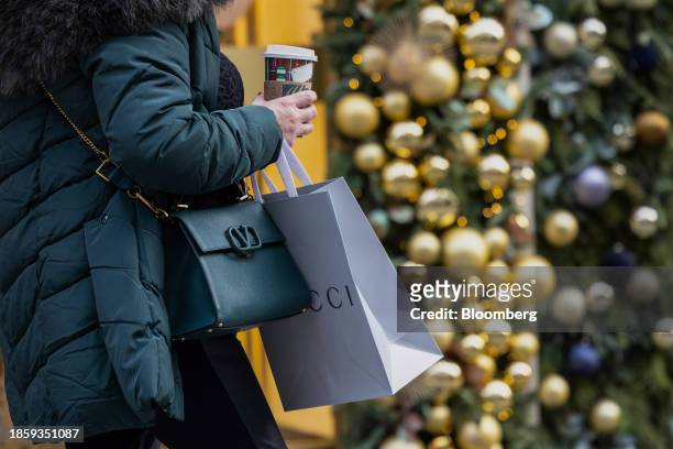Shopper with a Gucci carrier bag on New Bond Street in London, UK, on Monday, Dec. 18, 2023. The Office for National Statistics are due to release...
