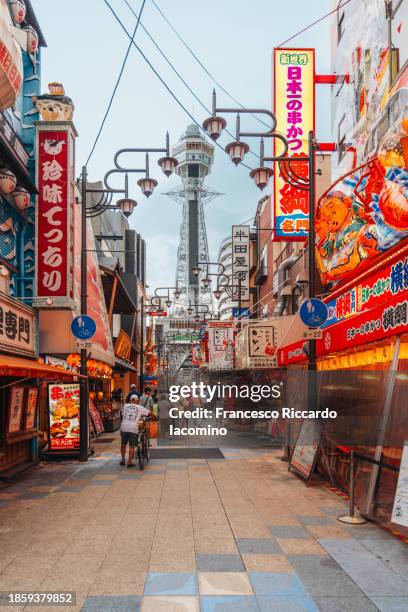 illuminated neon signs at sunset in osaka city center - stadt osaka stock-fotos und bilder