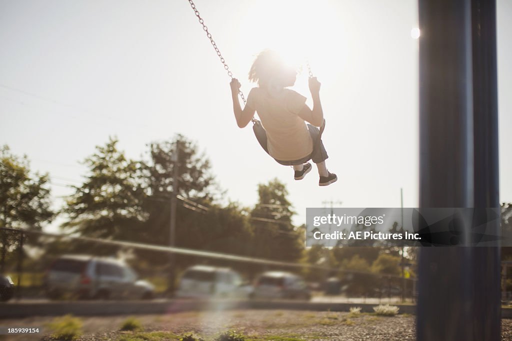 Girl swinging in sunset