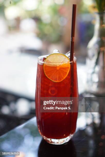 black lemon iced tea drink in crystal clear water and on the wooden table. beverage - condensation stock pictures, royalty-free photos & images