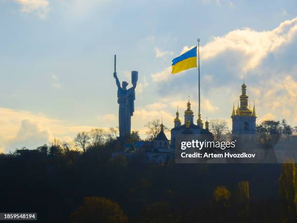 motherland mother monument. ukrainian flag waving on wind - kiev fotografías e imágenes de stock