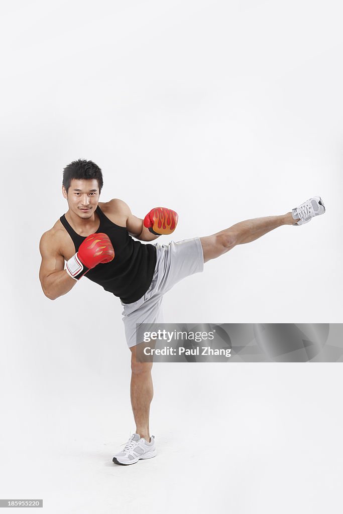 Chinese man wearing boxing gloves in gym