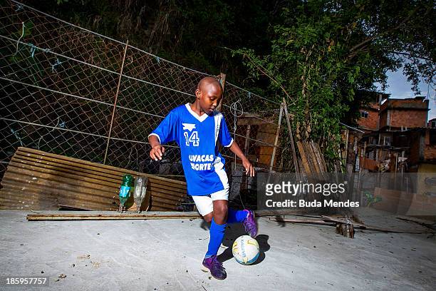Samuca, athlete of Vila Nova Project, plays football on the rooftops in the Morro dos Macacos area on October 26, 2013 in Rio de Janeiro, Brazil. The...