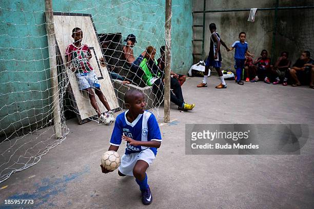 Samuca plays football at the Vila Nova Project in the Morro dos Macacos area on October 26, 2013 in Rio de Janeiro, Brazil. The Project Vila Nova was...