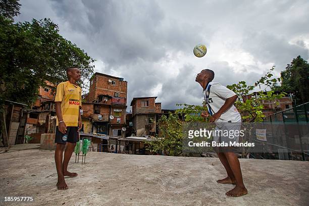 Carlinhos and Maycon, athletes of Vila Nova Project, play football on the rooftops in the Morro dos Macacos area on October 26, 2013 in Rio de...