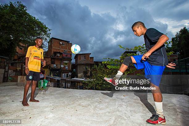 Carlinhos and Baiano, athletes of Vila Nova Project, play football on the rooftops in the Morro dos Macacos area on October 26, 2013 in Rio de...