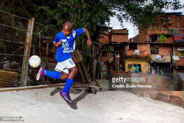 Samuca, athlete of Vila Nova Project, plays football on the rooftops in the Morro dos Macacos area on October 26, 2013 in Rio de Janeiro, Brazil. The...
