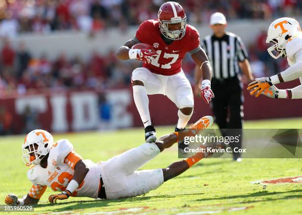 Kenyan Drake of the Alabama Crimson Tide rushes over LaDarrell McNeil of the Tennessee Volunteers at Bryant-Denny Stadium on October 26, 2013 in...