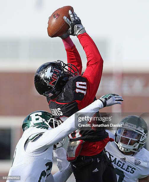 Tommylee Lewis of the Northern Illinois Huskies tries to make a catch as he is hit by Ja'Ron Gillespie and Donald Coleman of the Eastern Michigan...