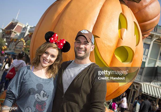 Actress Alyssa Milano of television series"Mistresses" and husband David Bugliari celebrate "Halloween Time" at Disneyland on October 26, 2013 in...
