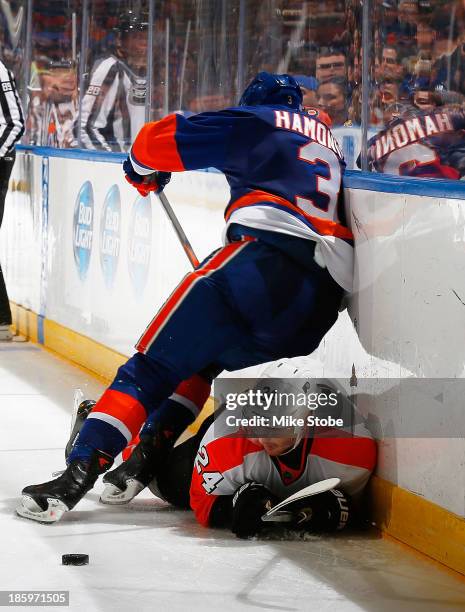 Matt Read of the Philadelphia Flyers falls to the ice battling for the puck with Travis Hamonic of the New York Islanders at Nassau Veterans Memorial...