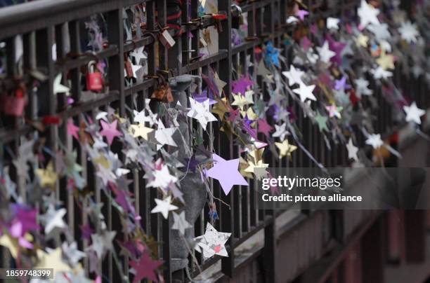 December 2023, Hamburg: Homemade stars made from yogurt and pudding lids hang from the Michaelis Bridge. In the world record attempt, the pupils want...