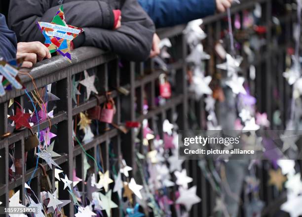December 2023, Hamburg: Homemade stars on yogurt and pudding lids hang from the Michaelis Bridge. In the world record attempt, the pupils want to...