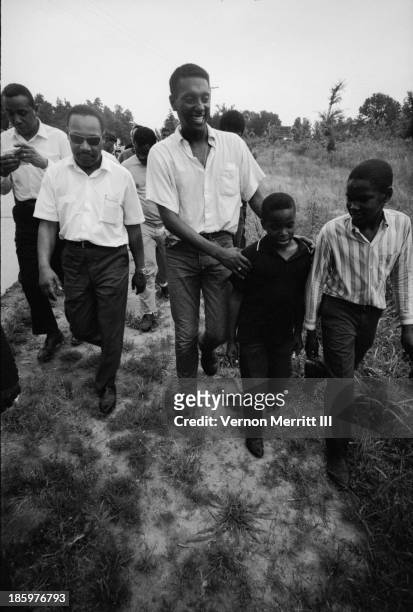 American Civil Rights leaders Dr Martin Luther King Jr and Trinidadian-born American Stokely Carmichael walk with others during a march to encourage...