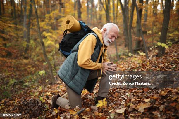 senior man treks on with an injured leg - knee arthritis stock pictures, royalty-free photos & images