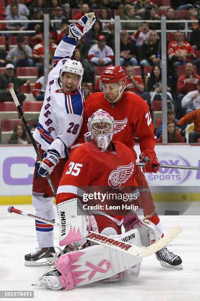 Dominic Moore of the New York Rangers celebrates the goal scored by teammate Mats Zuccarello as Brian Lashoff and goalie Jimmy Howard of the Detroit...