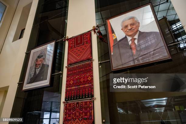 Portraits of the President of the Palestinian Authority Mahmoud Abbas and the late Palestinian leader Yassir Arafat hang in the building of the...