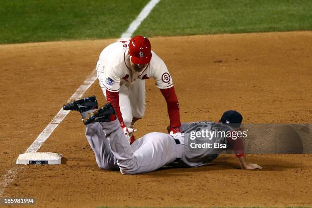 Allen Craig of the St. Louis Cardinals gets tripped up by Will Middlebrooks of the Boston Red Sox during the ninth inning of Game Three of the 2013...