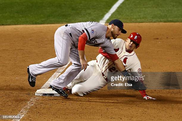 Allen Craig of the St. Louis Cardinals gets tripped up by Will Middlebrooks of the Boston Red Sox during the ninth inning of Game Three of the 2013...