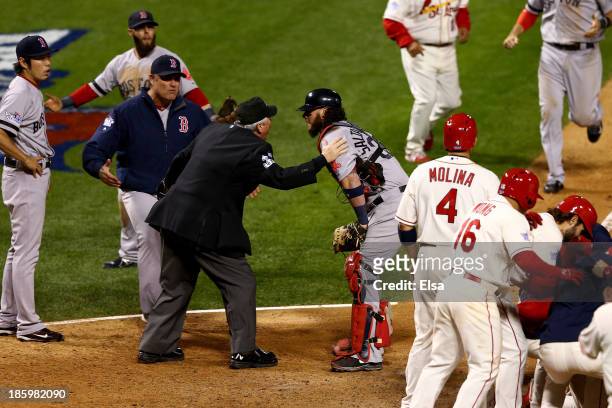 Manager John Farrell and Jarrod Saltalamacchia of the Boston Red Sox argue an obstruction call with Home Plate Umpire Dana DeMuth in the ninth inning...