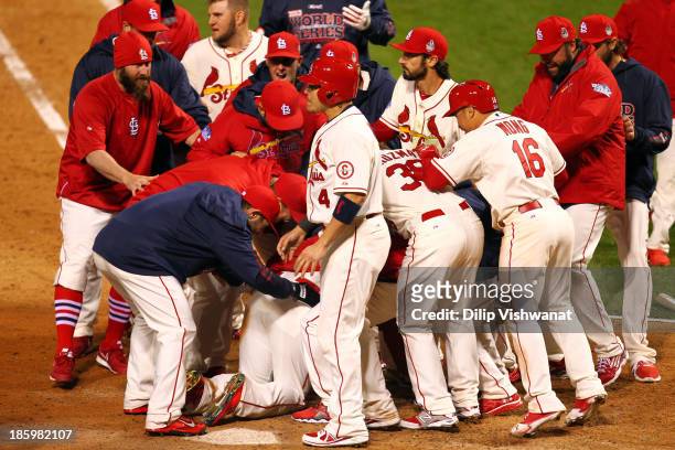The St. Louis Cardinals surround Allen Craig after he scored the winning run against the Boston Red Sox in the ninth inning during Game Three of the...