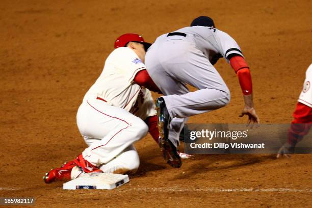 Allen Craig of the St. Louis Cardinals gets tripped up by Will Middlebrooks of the Boston Red Sox during the ninth inning of Game Three of the 2013...