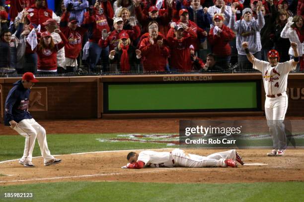 Allen Craig of the St. Louis Cardinals lays next to home plate after scoring the winning run against the Boston Red Sox in the ninth inning during...