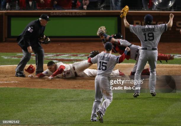 Home plate umpire Dana DeMuth calls Allen Craig of the St. Louis Cardinals safe at home against Jarrod Saltalamacchia of the Boston Red Sox in the...