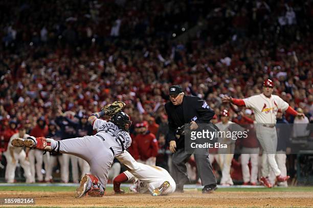Home plate umpire Dana DeMuth calls Allen Craig of the St. Louis Cardinals safe at home as Jarrod Saltalamacchia of the Boston Red Sox reacts in the...