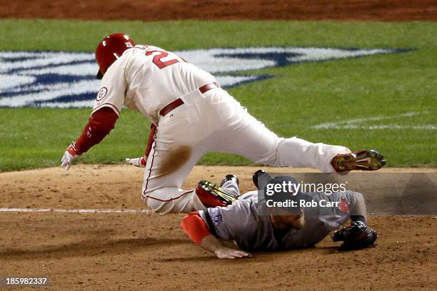 Allen Craig of the St. Louis Cardinals gets tripped up at third base by Will Middlebrooks of the Boston Red Sox during the ninth inning of Game Three...