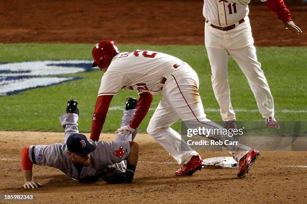 Allen Craig of the St. Louis Cardinals gets tripped up at third base by Will Middlebrooks of the Boston Red Sox during the ninth inning of Game Three...
