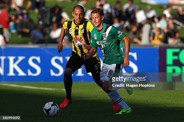 Nathan Burns of the Jets runs the ball under pressure from Leo Bertos of the Phoenix during the round three A-League match between Wellington Phoenix...