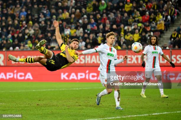 Niclas Fuellkrug of Borussia Dortmund reacts in the air as he is challenged by Robert Gumny of FC Augsburg during the Bundesliga match between FC...