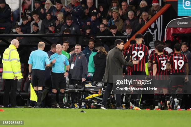 Referee Simon Hooper looks on as players of Luton Town and AFC Bournemouth leave the field as Tom Lockyer of Luton Town receives medical treatment...