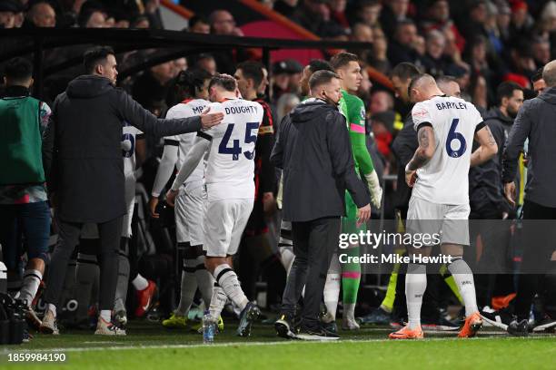 Players of Luton Town and AFC Bournemouth leave the field as Tom Lockyer of Luton Town receives medical treatment after collapsing during the Premier...