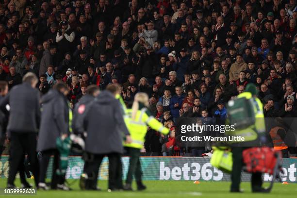 Fans of AFC Bournemouth applaud as Tom Lockyer of Luton Town leaves the field on a stretcher after receiving medical treatment after collapsing...