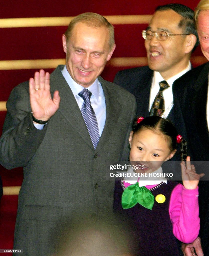 Putin Wave Russian President Vladimir Putin and a young Chinese gril wave to ...