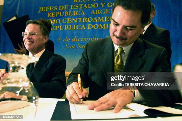 Guatemalan President Alfonso Portillo is seen next to the President of Costa Rica Miguel Angel Rodriguez signing a document 04 September 2000....