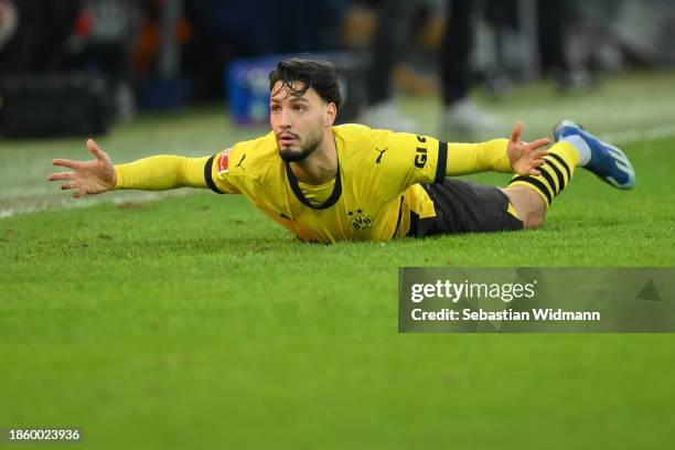 Ramy Bensebaini of Borussia Dortmund lies on the pitch during the Bundesliga match between FC Augsburg and Borussia Dortmund at WWK-Arena on December...